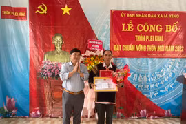 Phó Chủ tịch UBND huyện Nguyễn Anh Tuấn trao quyết định công nhận đạt chuẩn nông thôn mới cho cán bộ và Nhân dân thôn Plei Kual. Ảnh: Vũ Chi