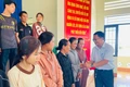 Bí thư Đảng ủy xã Phạm Văn Phương trao tặng thẻ bảo hiểm y tế cho các công dân bị ngộ độc thực phẩm. Ảnh: Vũ Chi