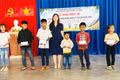 Phó Chủ tịch UBND xã Lưu Thị Thương tặng quà cho các em học sinh có hoàn cảnh khó khăn. Ảnh: ĐVCC