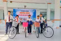 Thầy Vũ Văn Tùng (bìa phải, người phụ trách Tủ bánh 0 đồng) phối hợp với Ban Giám hiệu Trường Tiểu học và THCS Đinh Núp tặng xe đạp cho các em học sinh có hoàn cảnh đặc biệt khó khăn của trường. Ảnh V.C