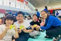 Chị Rah Lan H’Thùy (Bí thư Chi đoàn tổ dân phố 6) tặng quà cho các em nhỏ tham gia sinh hoạt hè. Ảnh: Vũ Chi