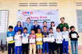 Ban tổ chức tặng học bổng cho các em học sinh nghèo tại điểm Trường Tiểu học Hùng Vương (buôn Ma Giai). Ảnh: ĐVCC