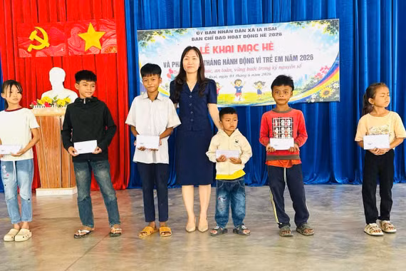 Phó Chủ tịch UBND xã Lưu Thị Thương tặng quà cho các em học sinh có hoàn cảnh khó khăn. Ảnh: ĐVCC