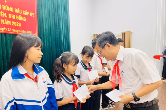 Chủ tịch UBND phường Ayun Pa Đặng Quang Khanh tặng quà cho các em học sinh tham gia hội nghị. Ảnh: Vũ Chi