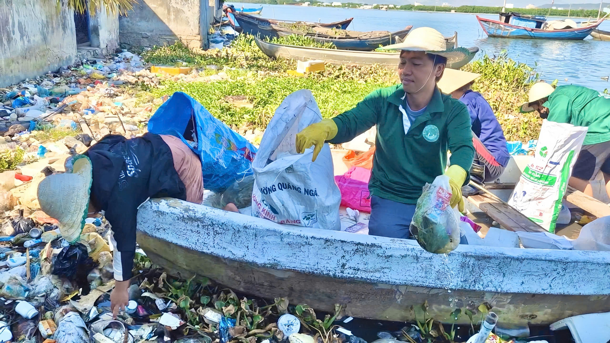 Anh Trần Trọng Nghĩa (phải) cùng các tình nguyện viên dọn rác khu vực ven đầm Thị Nại. Ảnh: HTX cung cấp gen-h-nghia.jpg