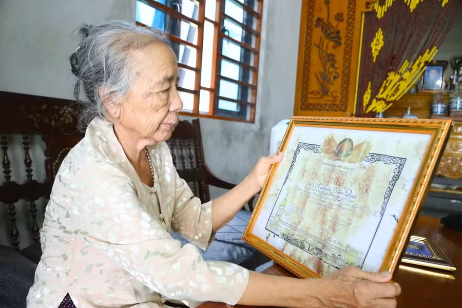 Bà Nguyễn Thị Ngọ bên Tấm bằng Tổ quốc ghi công liệt sĩ Nguyễn Văn Đinh