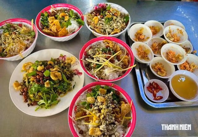 Cơm nguội được trộn cùng hến, rau sống, đậu phộng, tóp mỡ, mắm ruốc, ớt và nước hến