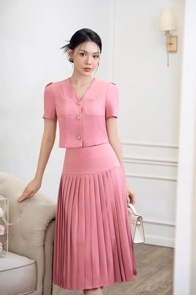 Set áo crop top và chân váy xếp ly tông hồng mang lại hình ảnh trẻ trung, hiện đại nhưng vẫn cực kỳ sang trọng