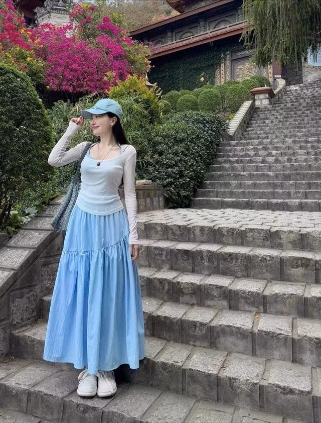 Chân váy dài màu xanh mint phối cùng áo dài tay mỏng, giày sneakers, mũ lưỡi trai là bản phối trẻ trung, năng động trong mùa hè này