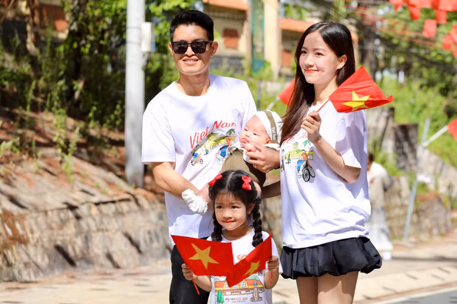 Không chỉ thu hút giới trẻ, nhiều gia đình trẻ cũng check-in trên những con đường rực rỡ sắc cờ Tổ quốc.