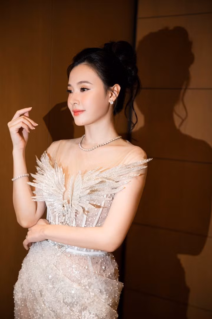 Diện bộ váy cúp ngực trắng tinh khôi, ôm sát cơ thể và làm từ chất liệu xuyên thấu đính đá tỉ mỉ, Midu khoe trọn vóc dáng nuột nà. Thiết kế tạo hiệu ứng phát sáng lấp lánh dưới ánh đèn flash, đồng thời kết hợp chi tiết cánh bướm tinh tế ngay phần ngực và đường xẻ tà cao đầy quyến rũ.