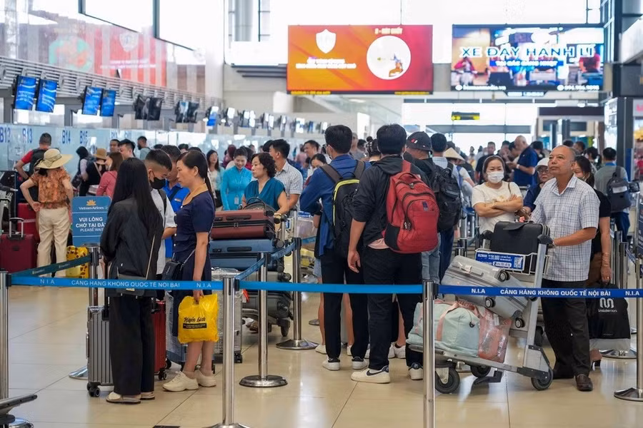Hành khách làm thủ tục chuyến bay tại Cảng Hàng không quốc tế Nội Bài. Ảnh: PV/Vietnam+