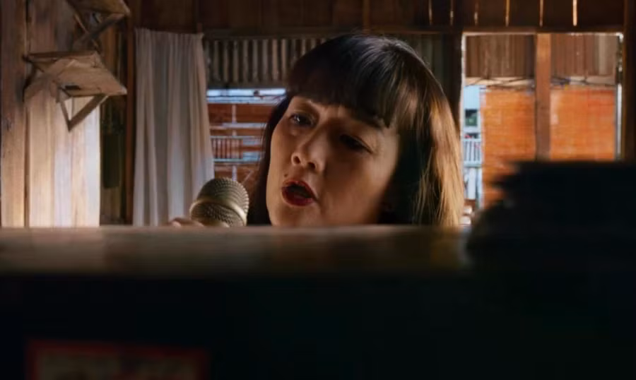 Vân Dung vào vai nạn nhân bị sát hại bằng micro trong "Án mạng karaoke." Ảnh từ phim