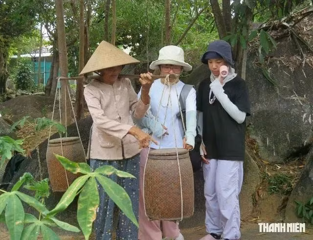 Cụ Trần Thị Chín giới thiệu đôi thùng mắm với du khách