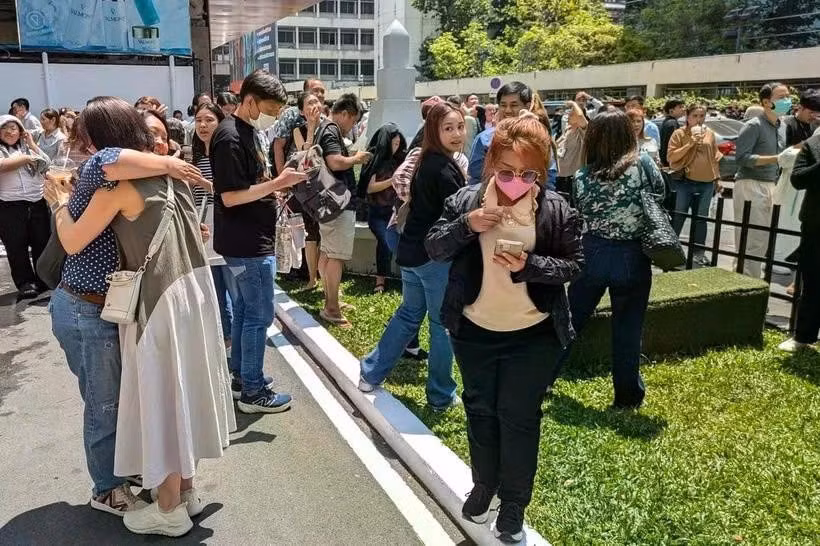 Người dân đứng bên ngoài một tòa nhà văn phòng ở Bangkok sau trận động đất. (Nguồn: AFP)
