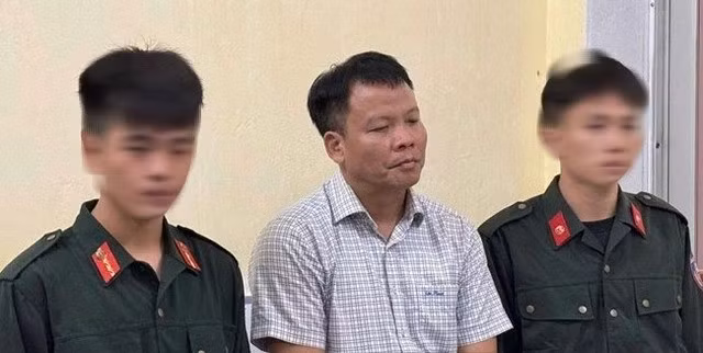 Ông Đồng Xuân Thụ, Tổng biên tập Tạp chí Môi trường và Đô thị Việt Nam (giữa), khi bị giữ khẩn cấp về tội cưỡng đoạt tài sản
