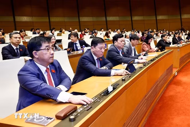 Đại biểu ấn nút thông qua luật, Nghị quyết. (Ảnh: Doãn Tấn/TTXVN)