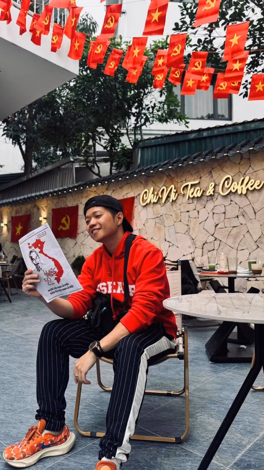 Bạn trẻ check-in tại không gian quán cà phê được trang trí cờ đỏ sao vàng dịp 30/4 để thể hiện tinh thần yêu nước. Ảnh: ChiNi