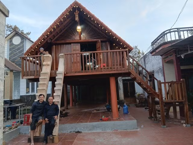 Y Wôn và thợ của mình trước căn nhà dài do anh phục dựng
