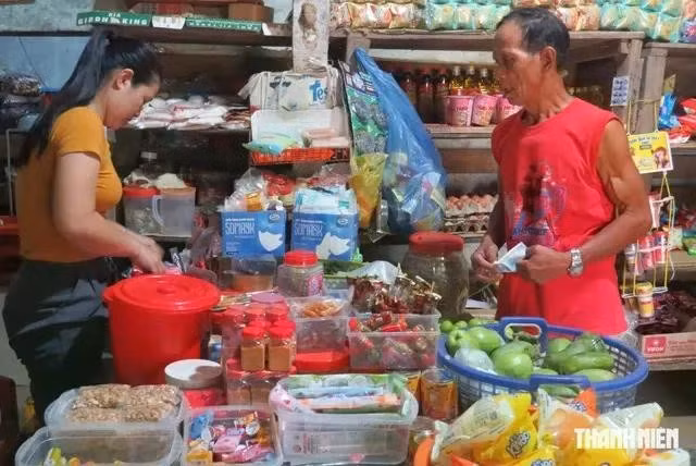 Chị Nguyễn Thị Thông (trái) bán hàng cho ông Phạm Văn Vui