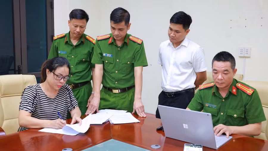 Cơ quan công an thi hành lệnh bắt bị can để tạm giam đối với Đặng Thị Lý (áo kẻ ngang).