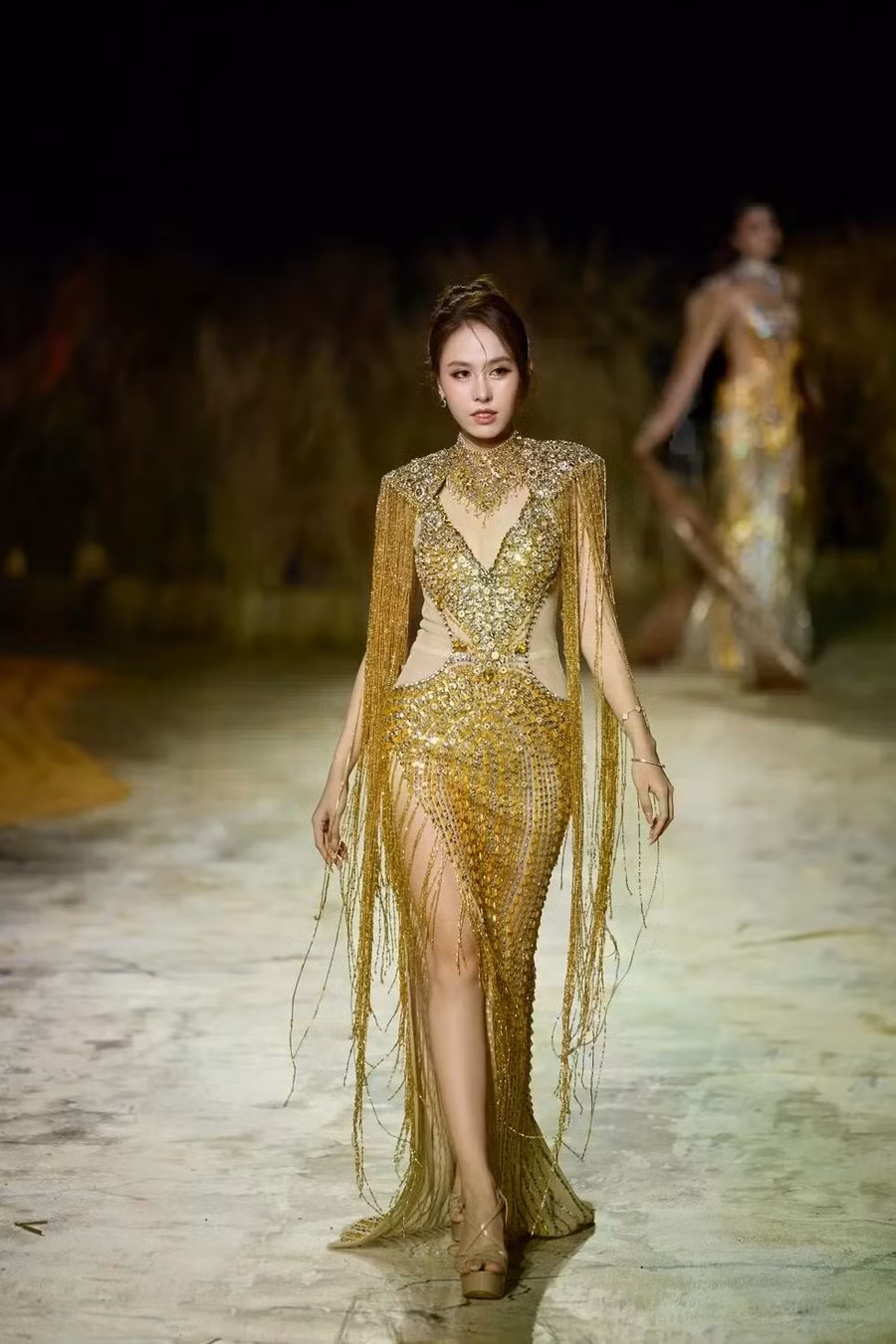 Dù sân khấu khá trơn sau cơn mưa to, Á hậu Lê Nguyễn Ngọc Hằng vẫn tỏa sáng trên sàn diễn với trang phục tua rua, được đính kết tỉ mỉ