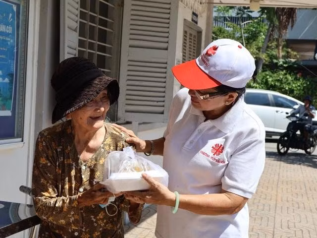 Cô Bông vừa trao cơm, vừa hỏi han sức khỏe của bà Đông