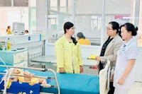Y-bác sĩ Bệnh viện Nhi tỉnh động viên chị Siu Bếp (bìa trái, làng O Grưng, xã Ia Ko, huyện Chư Sê) cố gắng cho con nằm viện điều trị. Ảnh: N.N