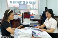 Công chức Đội thuế liên huyện Pleiku-Ia Grai-Chư Păh hướng dẫn người nộp thuế về thủ tục hành chính. Ảnh: S.C