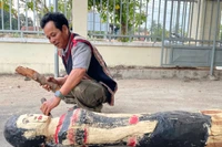 Nghệ nhân Nay Lâm hoàn thiện bức tượng gỗ người phụ nữ Jrai. Ảnh: V.C