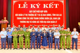 Đội QLTT số 7 và UBND xã Kon Gang ký quy chế phối hợp trong đấu tranh chống buôn lậu, gian lận thương mại và hàng giả. Ảnh: V.T