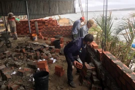 Người dân khẩn trương dựng lại chuồng trại chăn nuôi bị thiệt hại nặng sau cơn bão số 13, nỗ lực khôi phục sản xuất.