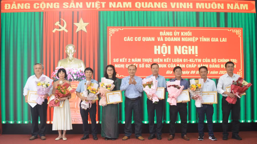 Bí thư Đảng ủy Khối các Cơ quan và Doanh nghiệp tỉnh Huỳnh Minh Thuận (đứng giữa) tặng giấy khen cho 8 tập thể có thành tích trong học tập và làm theo tư tưởng, đạo đức, phong cách Hồ Chí Minh. Ảnh: Phương Dung