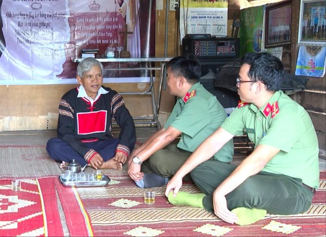 Ông Nay Ku và cán bộ công an huyện trò chuyện.