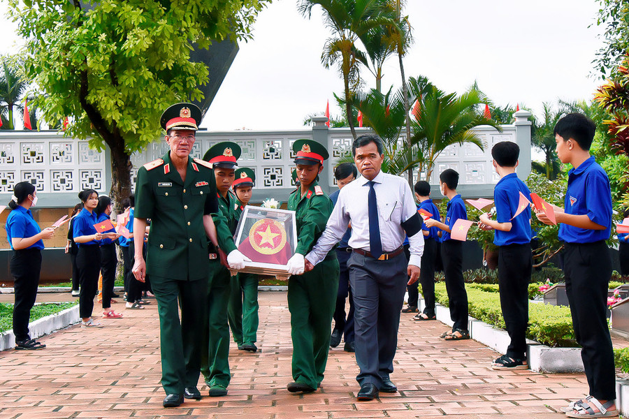 Ủy viên Ban Chấp hành Trung ương Đảng, Bí thư Tỉnh ủy, Chủ tịch HĐND tỉnh Hồ Văn Niên (bên phải) đưa hài cốt liệt sĩ đến nơi an táng. Ảnh: Đức Thụy