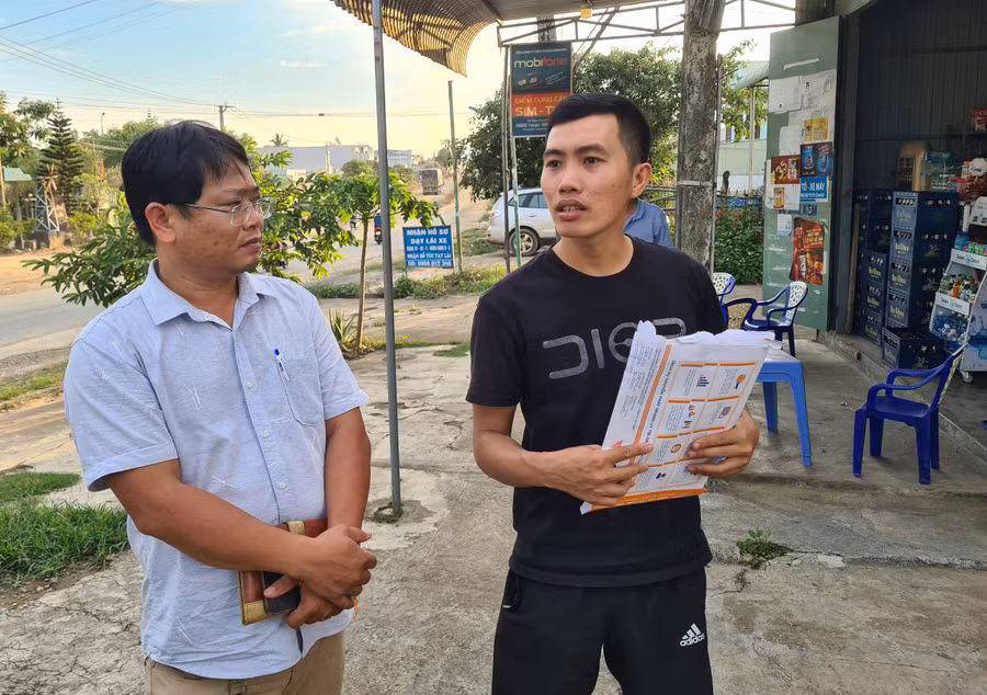 Anh Nguyễn Quốc Vương (bên phải, thôn An Sơn, xã Cư An) trao đổi với P.V về diện tích đất của gia đình bị thu hồi. Ảnh: Phạm Ngọc