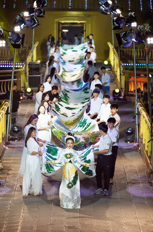 Nhà thiết kế Phương Hồ xác lập kỷ lục với chiếc áo dài 220,6m - Ảnh 2. Hình ảnh chiếc áo dài in 31 bức tranh của nhà thiết kế Phương Hồ. Sau khi trình diễn ở trong nước và quốc tế, cô sẽ biến nó thành 100 mẫu áo dài bình thường, bán đấu giá thực hiện dự án thiện nguyện. Ảnh: NVCC