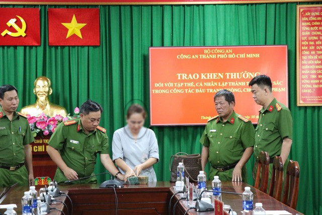 Công an trao trả 1,1 tỉ đồng cho nạn nhân (áo trắng) Công an trao trả 1,1 tỉ đồng cho nạn nhân (áo trắng)