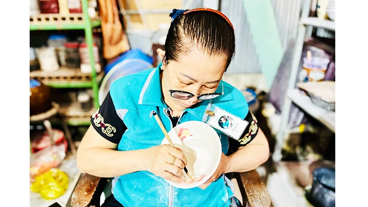 Chị Trần Thị Yến tỉ mỉ với nét vẽ truyền thống trên gốm Lái Thiêu. Chị Trần Thị Yến tỉ mỉ với nét vẽ truyền thống trên gốm Lái Thiêu.
