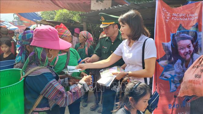 Phát tờ rơi tuyên truyền về phòng, chống mua bán người cho phụ nữ dân tộc thiểu số tại chợ trung tâm xã Tả Gia Khâu, huyện Mường Khương, tỉnh Lào Cai. Ảnh: Hương Thu/TTXVN