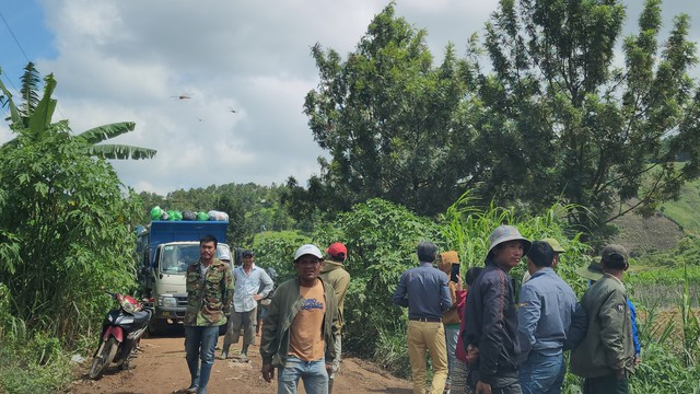 Người dân tụ tập trên con đường xe chở rác vào bãi xử lý. Ảnh: Lâm Viên