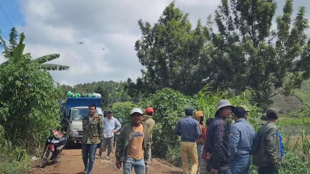 Người dân tụ tập trên con đường xe chở rác vào bãi xử lý. Ảnh: Lâm Viên