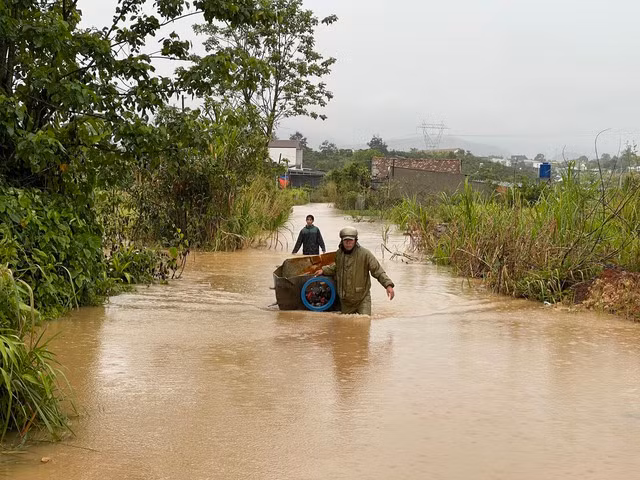 Di chuyển "tài sản" chạy lũ. Ảnh: G.B