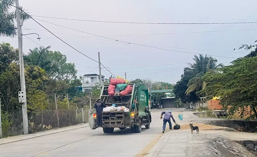 Xe chuyên dụng của Ban Quản lý dịch vụ công ích thị xã thu gom rác thải do người dân bỏ sẵn trước cửa nhà. Ảnh: Vũ Chi