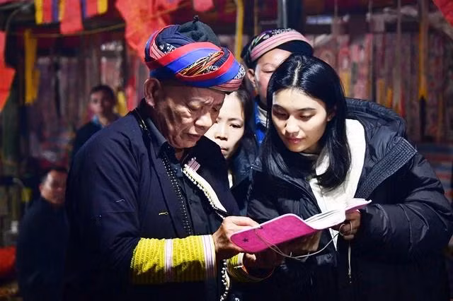 Nhà nghiên cứu Khưu Dĩnh (phải) được thầy cúng Chảo Tờ Quẩy giải đáp những thắc mắc trong lễ cấp sắc 12 đèn