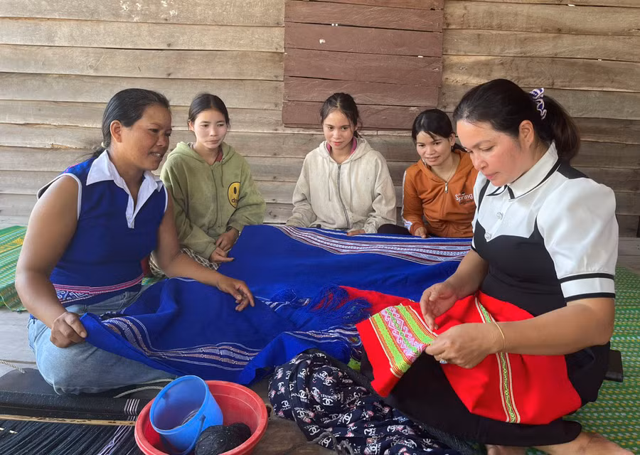 Chị em phụ nữ Bahnar trong Tổ dệt thổ cẩm chia sẻ kinh nghiệm để có thể dệt được những tấm thổ cẩm với hoa văn sắc sảo. Ảnh: Vũ Chi