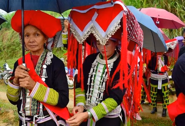 Học trò đeo băng đỏ cho bà Triệu Nhị Muội, làm nghi thức nhận bà làm sư phụ để học “cái lý” người Dao