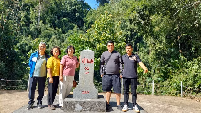 Du khách chụp ảnh tại cột mốc 62 (2) bên bờ sông Đăk Huýt