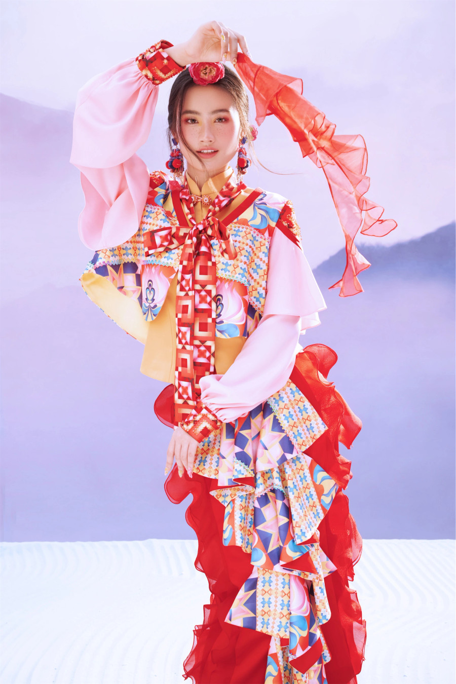 Những ô màu hình thoi trên bản vẽ tưởng chừng đặt để ngẫu nhiên, nhưng lại có những hàng, lớp và quy luật nhất định, đảm bảo được tính cân bằng chủ đạo trong trang trí hoa văn trên chiếc khăn biểu tượng. Khi diện trang phục với họa tiết lạ mắt, Ý Nhi còn kết hợp cùng vòng cổ, hoa tai, búi tóc đồng điệu