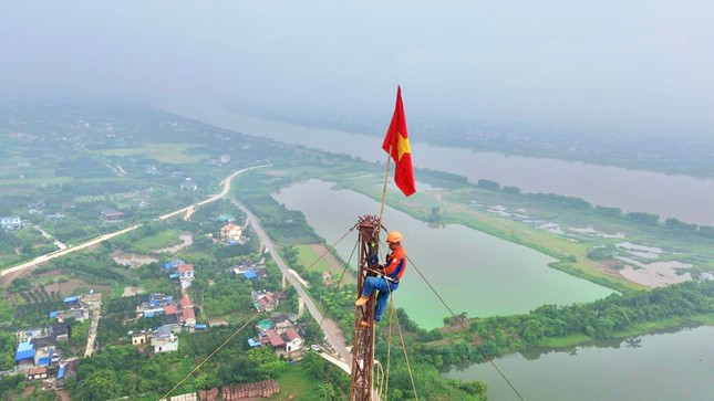 Công nhân làm việc trên cần bích dựng trụ ở độ cao gần 100m tại cột thép số 119 tại xã Nam Thắng (Nam Trực, Nam Định). Ảnh: Hoàng Mạnh Thắng.